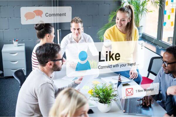 Equipo de cinco personas analizan sonrientes los resultados satisfactorios de su última estrategia de marketing  en las redes sociales